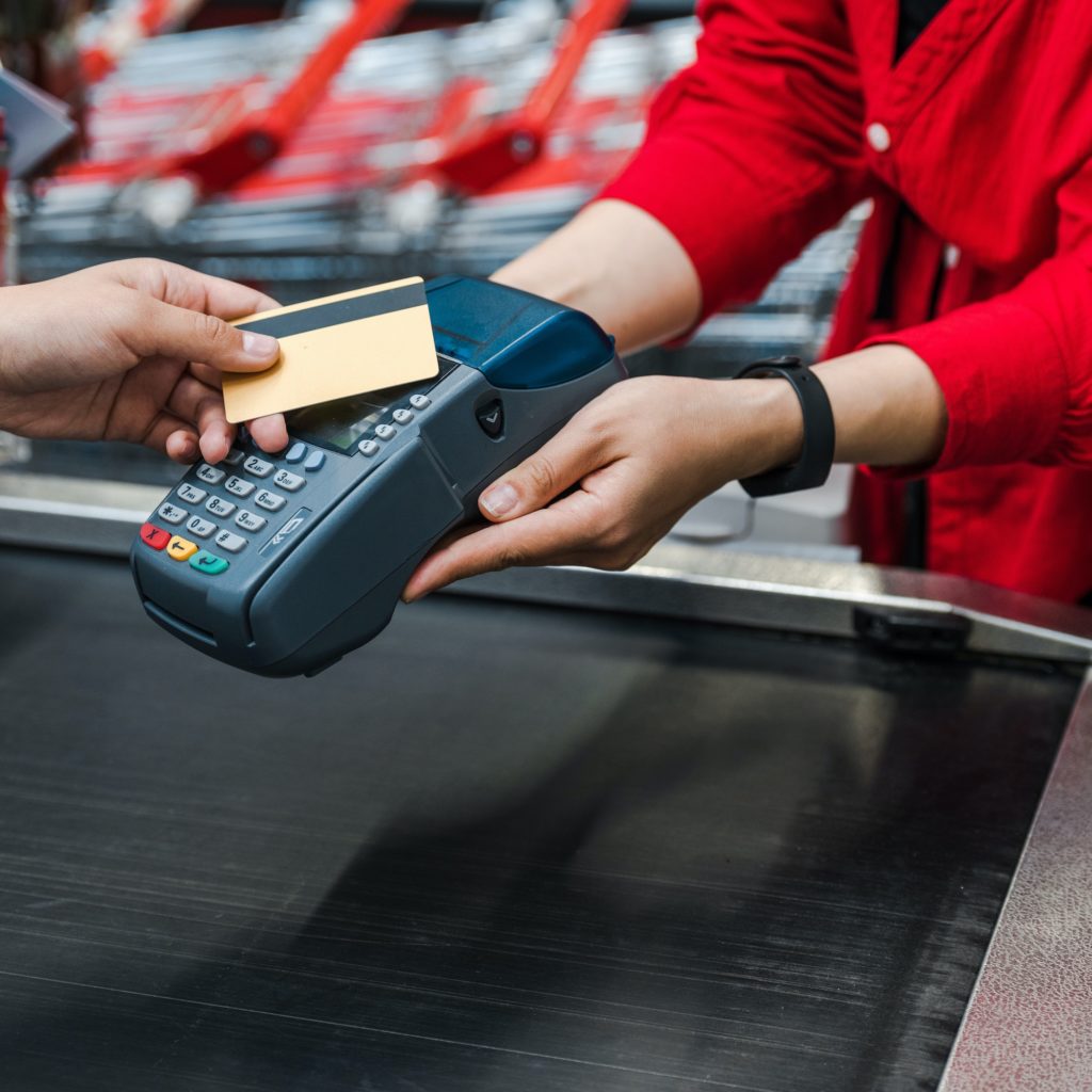 cropped view of man paying by credit card near woman in supermarket